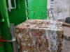 gepresster Papierballen fällt aus Ballenpresse auf Palette